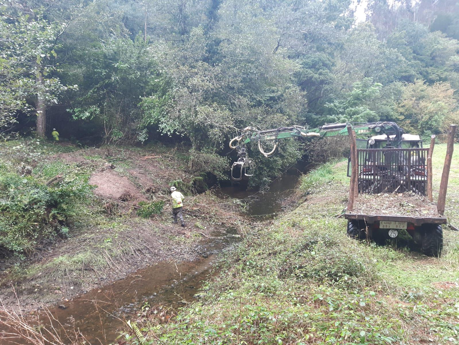 Imagen Operario y autocargador retirando restos vegetales de la margen en Santo Tomé